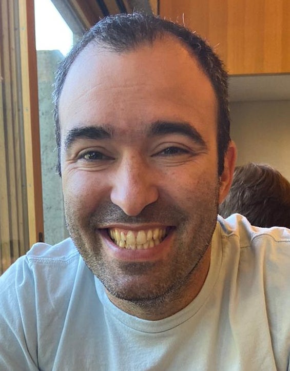 headshot of a man with brow hair smiling