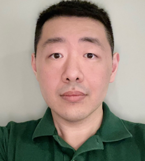 Headshot of an East Asian man with light skin and black short hair wearing a dark green polo shirt